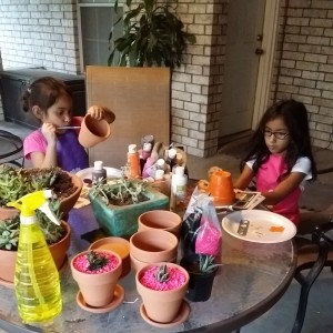 The girls, painting pots while I re-pot my babies.